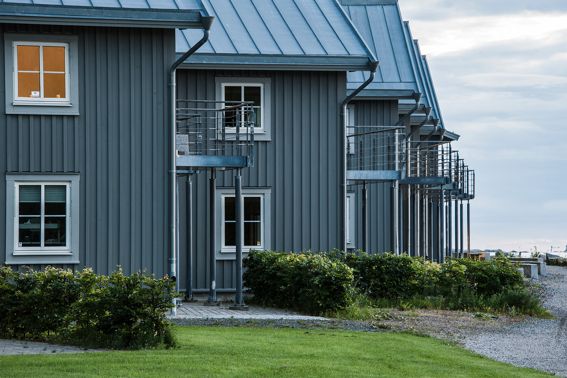 Holzfassade mit überlappender Bodendeckelschalung in natürlicher Holzoptik.