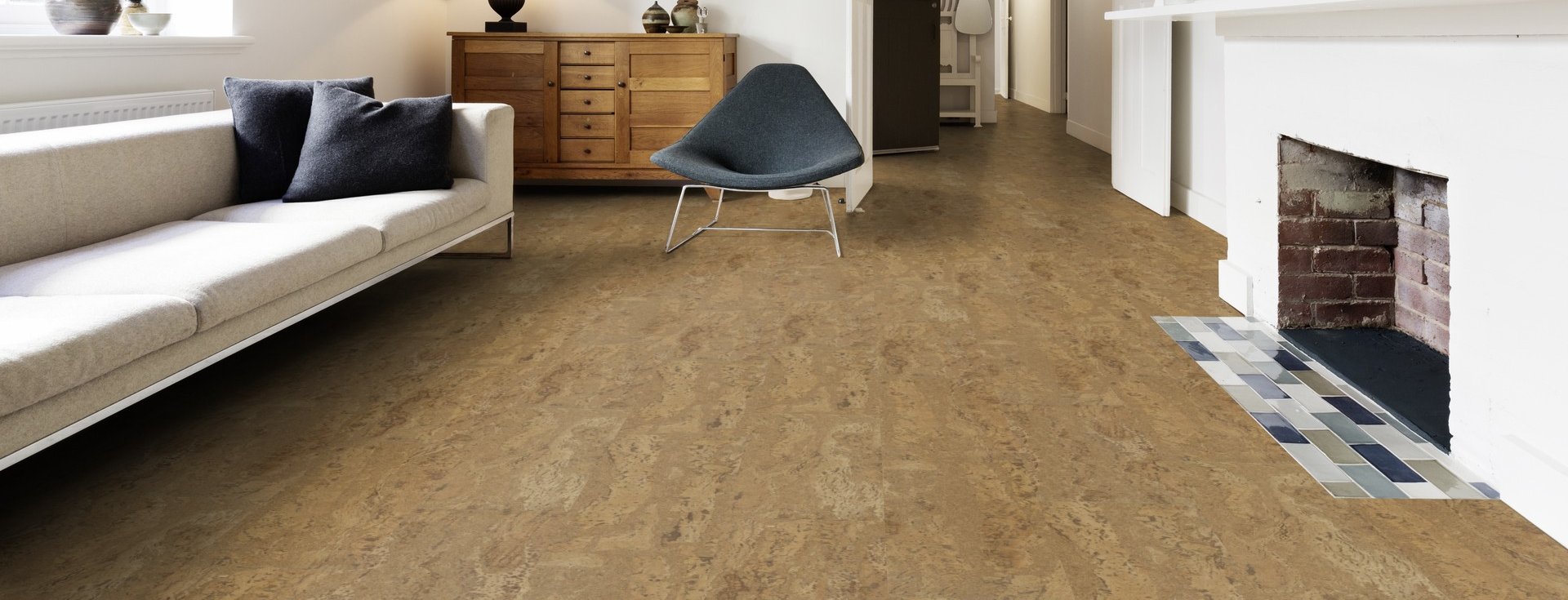 Ein Wohnzimmer mit einem Kamin und einem dunklen Korkboden