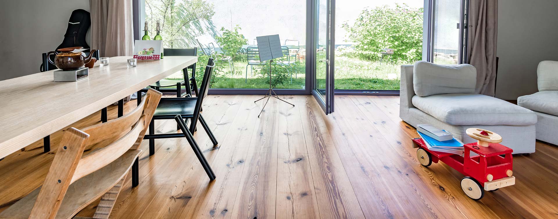 ein moderner Wohnbereich mit einem dunklen Boden aus Massivholzdielen